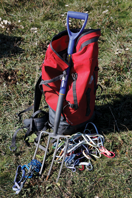 A garden fork leant against a ruck sack